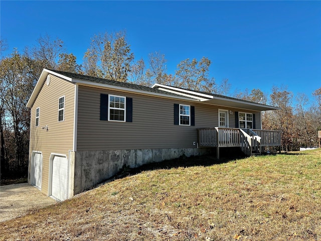 view of front facade with a garage, a front lawn, and a wooden deck