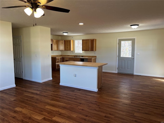 kitchen featuring a center island, dark hardwood / wood-style floors, ceiling fan, and sink