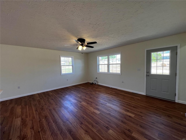 interior space with a textured ceiling, dark hardwood / wood-style floors, and ceiling fan