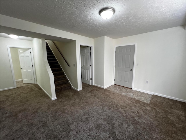 basement with dark carpet and a textured ceiling