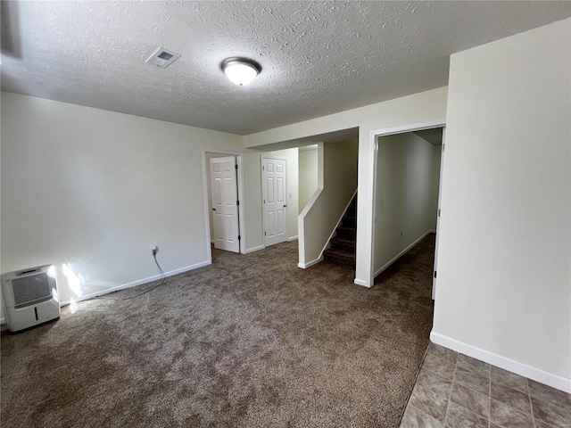 interior space with dark colored carpet and a textured ceiling