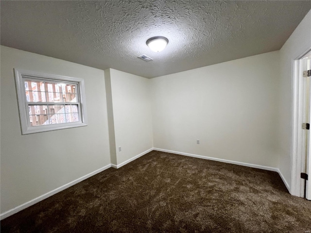 carpeted spare room with a textured ceiling