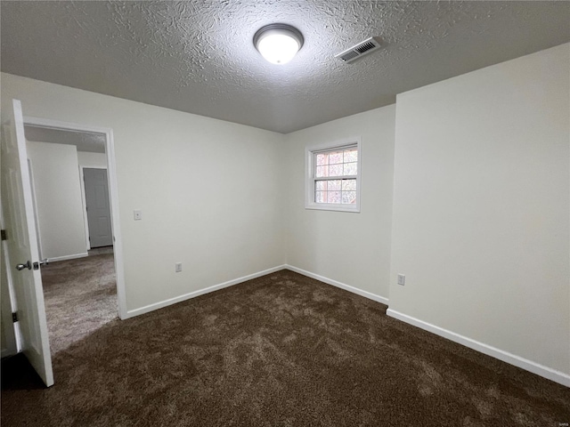 carpeted empty room with a textured ceiling