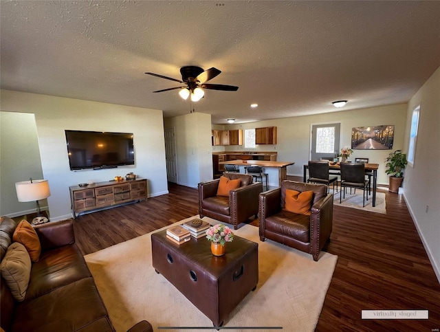 living room with a textured ceiling, hardwood / wood-style flooring, and ceiling fan