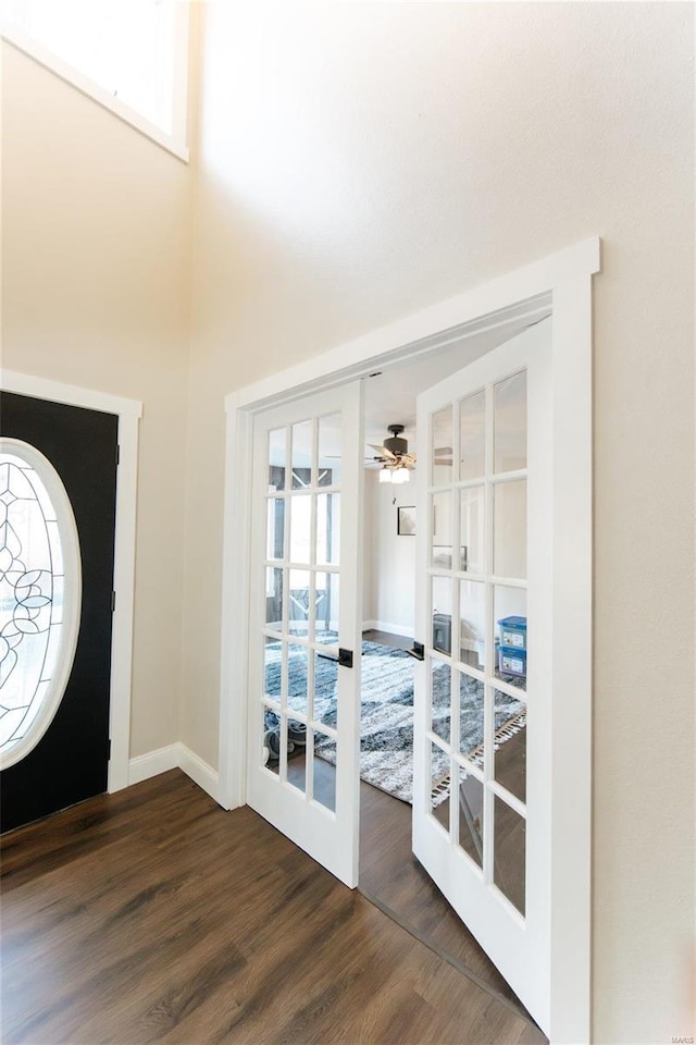 foyer featuring french doors, ceiling fan, and dark wood-type flooring