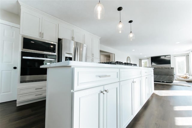 kitchen with white cabinetry, hanging light fixtures, appliances with stainless steel finishes, and dark wood-type flooring