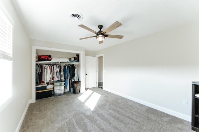 unfurnished bedroom featuring ceiling fan, light carpet, and a closet