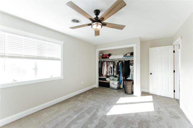 unfurnished bedroom with ceiling fan, a closet, and light carpet