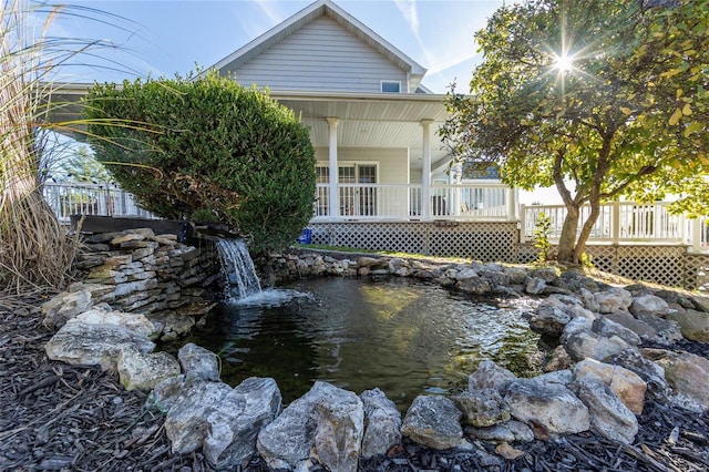 exterior space featuring a wooden deck and a small pond