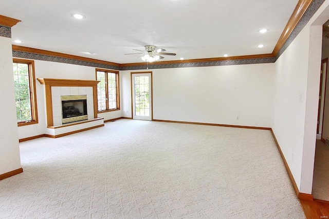 unfurnished living room with ornamental molding, a fireplace, a healthy amount of sunlight, and ceiling fan