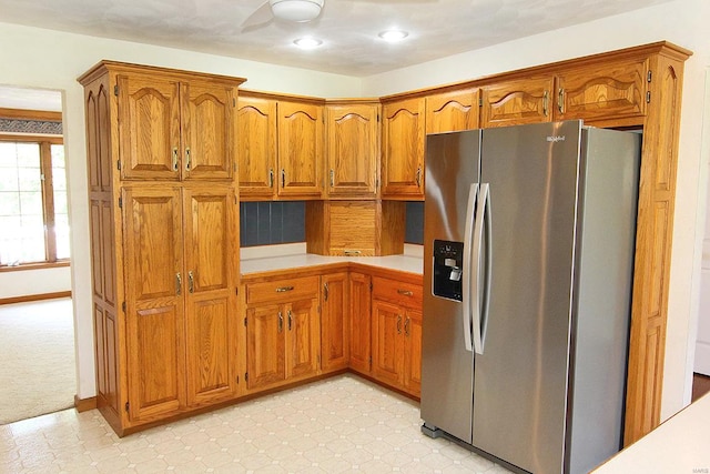 kitchen featuring stainless steel fridge with ice dispenser and light colored carpet