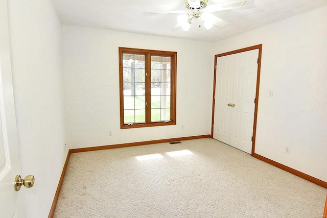 spare room featuring ceiling fan and light carpet