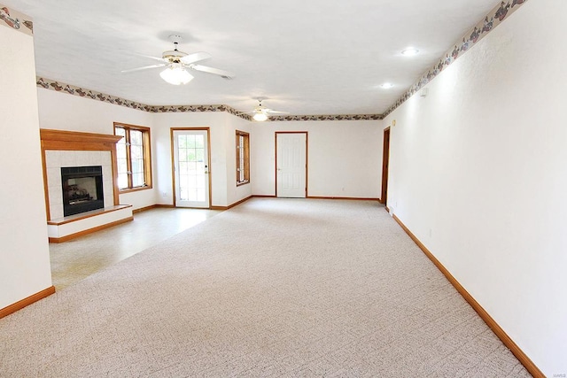 unfurnished living room featuring light carpet, ceiling fan, and a fireplace