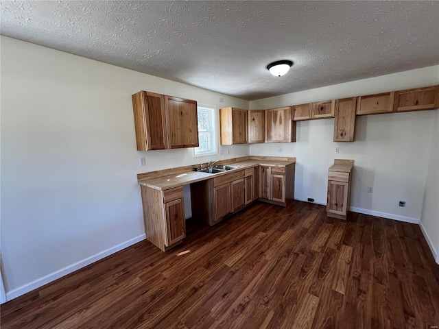 kitchen with a textured ceiling, dark hardwood / wood-style floors, and sink