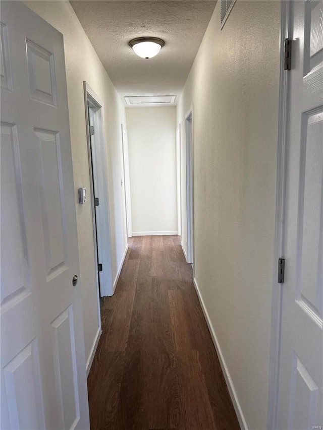 hall featuring dark hardwood / wood-style flooring and a textured ceiling