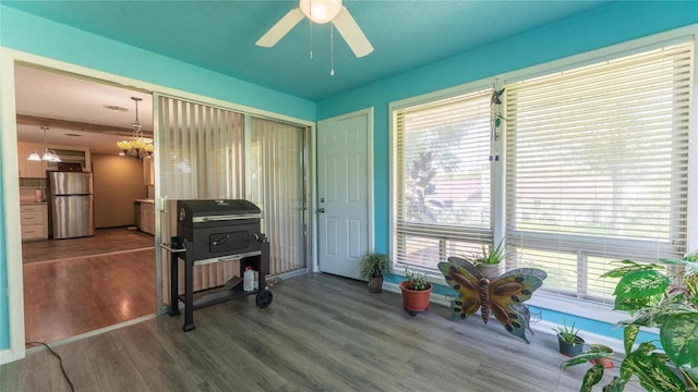 interior space with hardwood / wood-style floors, ceiling fan with notable chandelier, and plenty of natural light