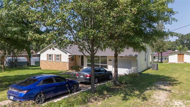 view of front of house with a front yard, a garage, and central air condition unit