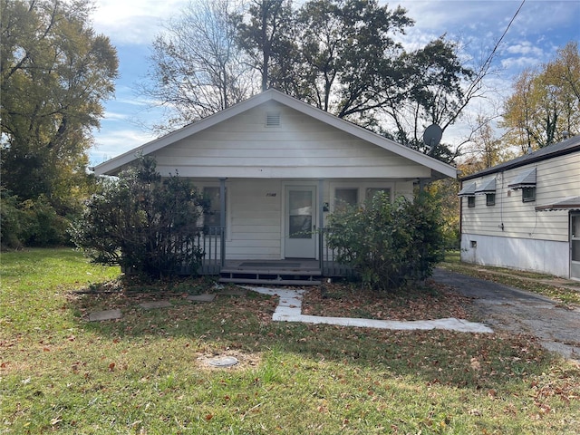 bungalow with a front lawn and covered porch