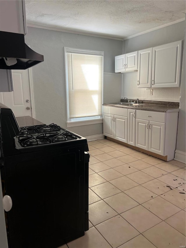 kitchen with white cabinets, light tile patterned flooring, black range, and crown molding