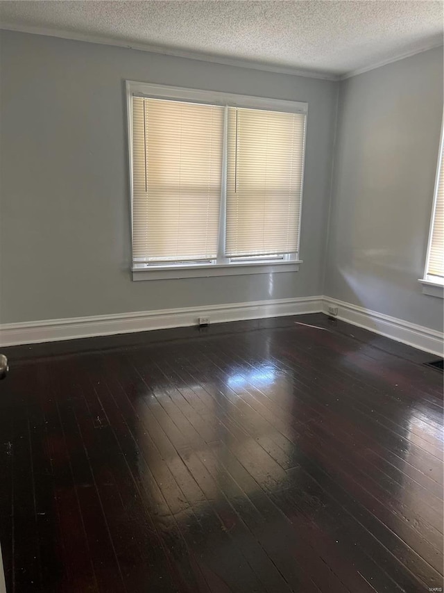 spare room featuring dark wood-type flooring and a textured ceiling