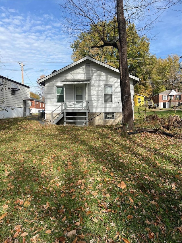 back of property featuring a lawn and cooling unit