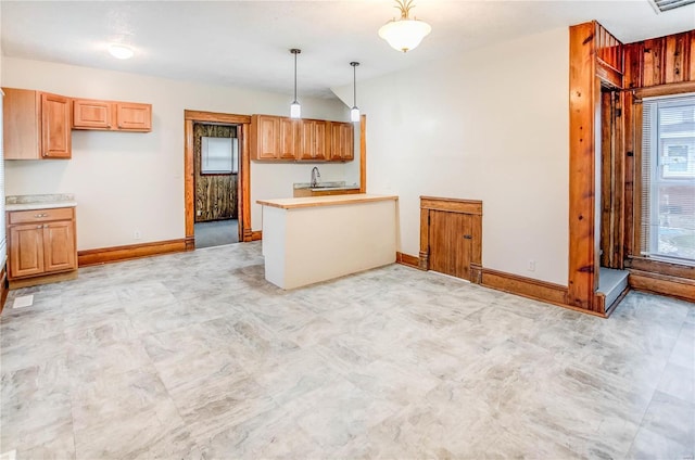 kitchen featuring pendant lighting, light brown cabinetry, and sink