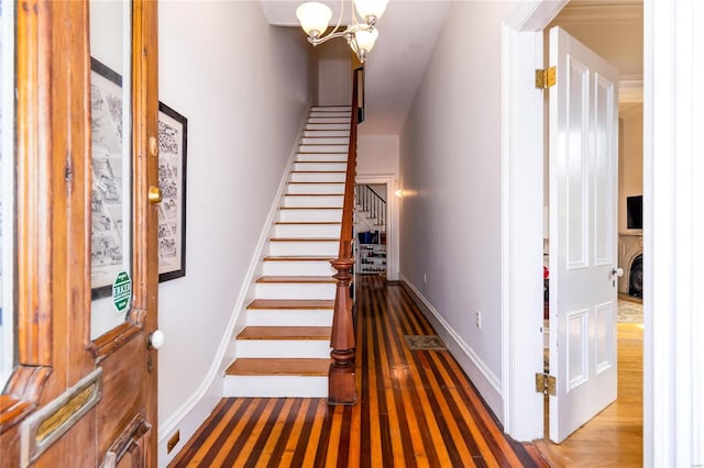 stairs featuring a chandelier and wood-type flooring