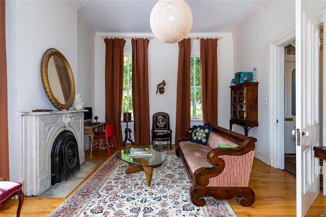 sitting room with ornamental molding and light hardwood / wood-style flooring