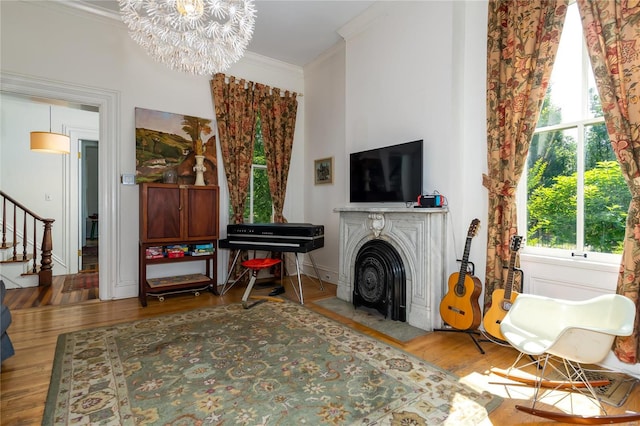 sitting room featuring wood-type flooring, a notable chandelier, and crown molding