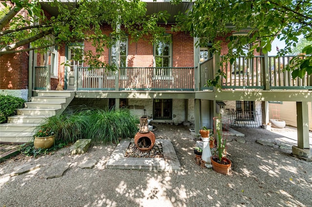 rear view of property with a patio, a fire pit, and a deck