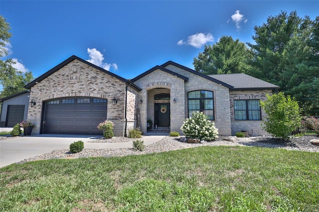 french provincial home featuring a front yard and a garage