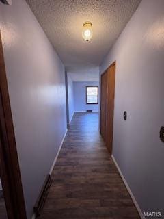 hallway with dark wood-type flooring and a textured ceiling