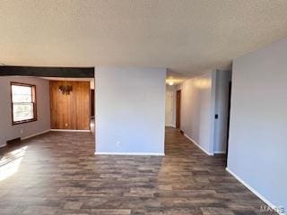 empty room with dark hardwood / wood-style floors and a textured ceiling