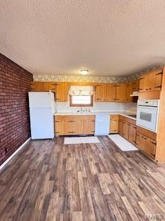 kitchen featuring white appliances, a textured ceiling, and dark hardwood / wood-style floors