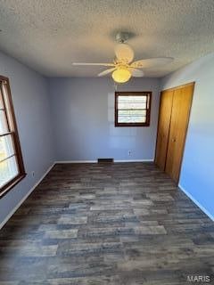 unfurnished bedroom featuring ceiling fan, a textured ceiling, and dark hardwood / wood-style flooring