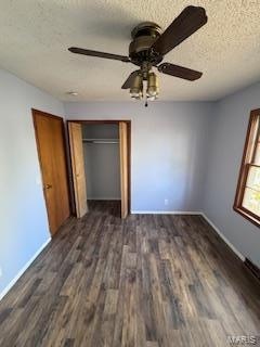 unfurnished bedroom with a textured ceiling, dark hardwood / wood-style floors, ceiling fan, and a closet