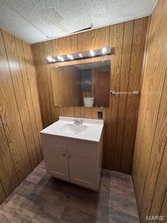 bathroom with vanity and wooden walls