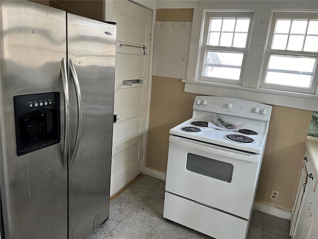 kitchen with white cabinetry, white range with electric stovetop, and stainless steel fridge