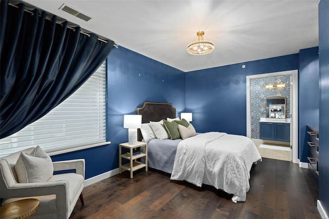 bedroom featuring a notable chandelier and dark wood-type flooring