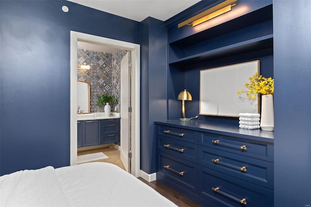 bedroom featuring dark wood-type flooring, sink, and ensuite bath