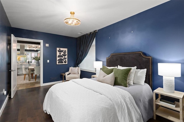 bedroom featuring dark hardwood / wood-style floors and an inviting chandelier