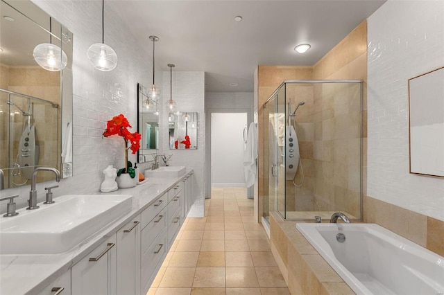 bathroom featuring tile patterned floors, vanity, tile walls, and shower with separate bathtub