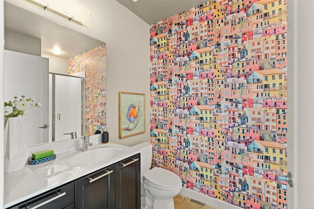 bathroom with tile patterned flooring, toilet, vanity, and walk in shower