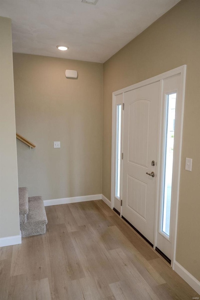 foyer entrance with light wood-type flooring and a wealth of natural light