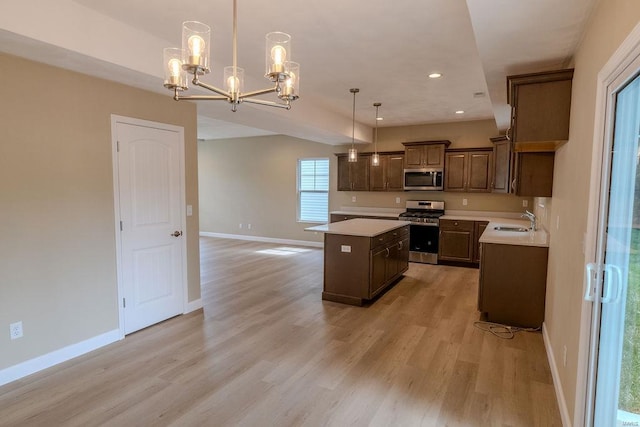 kitchen featuring light hardwood / wood-style floors, stainless steel appliances, sink, a kitchen island, and pendant lighting