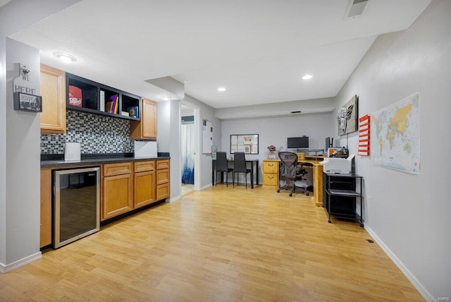 kitchen featuring light wood-type flooring, tasteful backsplash, and wine cooler