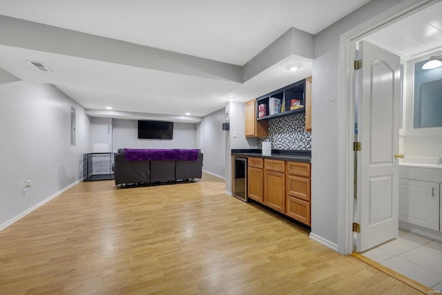 interior space featuring light hardwood / wood-style floors, backsplash, and wine cooler