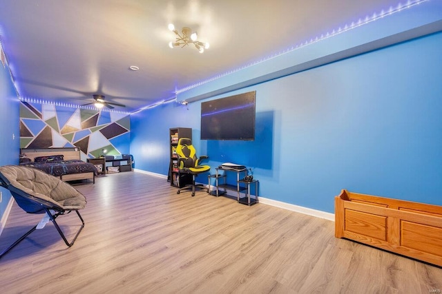 living room with light hardwood / wood-style flooring and ceiling fan with notable chandelier