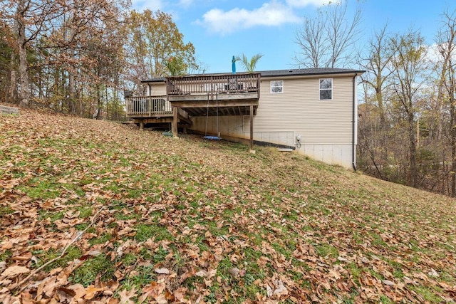 rear view of house with a yard and a wooden deck