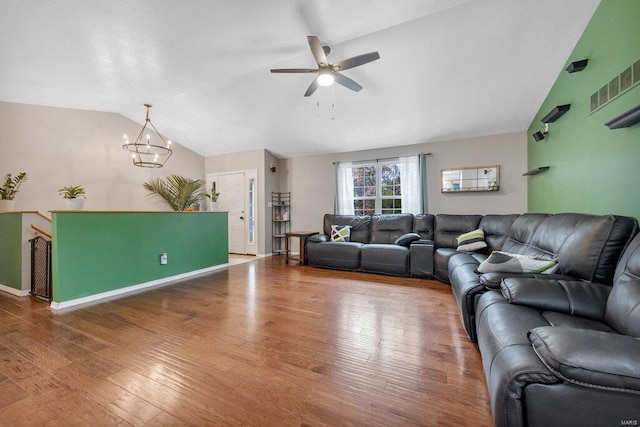 living room with ceiling fan with notable chandelier, lofted ceiling, and hardwood / wood-style floors